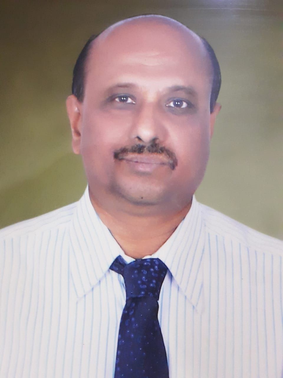 A person wearing a white shirt with blue vertical stripes and a navy blue tie.